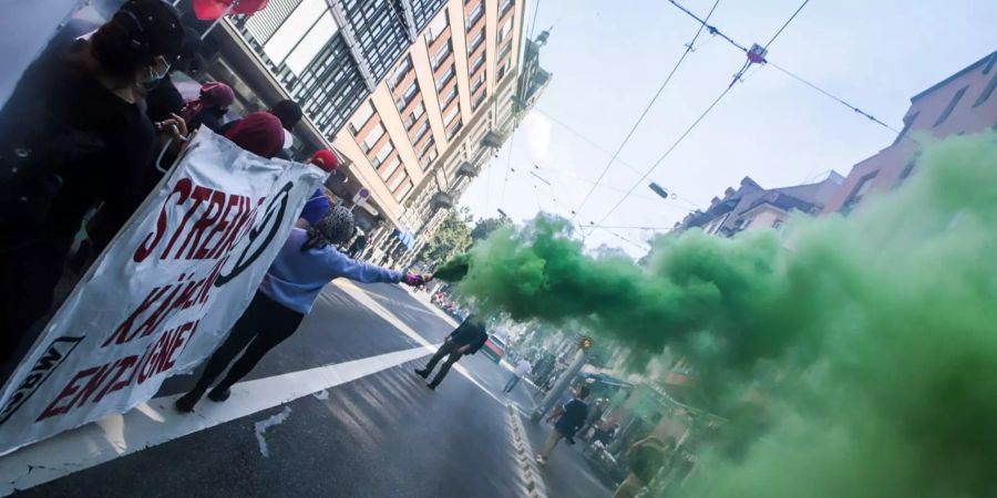 Demonstranten mit grünen Pyros in Zürich.