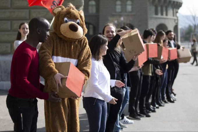 Mitglieder der Juso reichen die Schachteln mit den Unterschriften weiter, bei der Einreichung der 99%-Initiative, am Dienstag, 2. April 2019 in Bern. 99%-Initiative