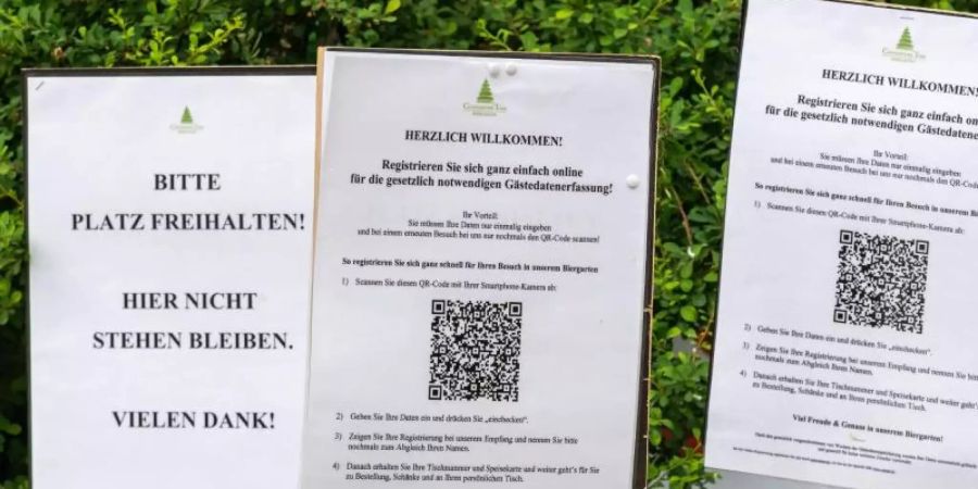 In der Corona-Krise: diverse Hinweisschilder vor einem Biergarten in Münchens Englischem Garten. Foto: Peter Kneffel/dpa