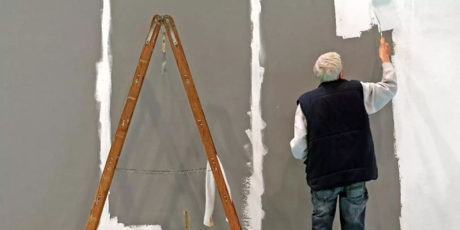 Ein älterer Mann streicht auf der Leipziger Messe eine Wand. Die Menschen in Deutschland beziehen immer länger Rente, zugleich sind sie in den vergangenen Jahren immer später in Rente gegangen. Foto: Jan Woitas/dpa-Zentralbild/dpa