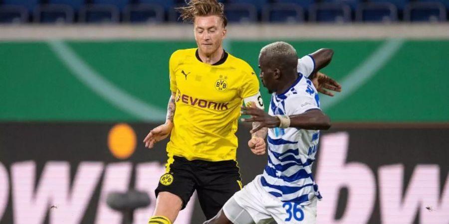 Marco Reus (l) von Borussia Dortmund und Wilson Kamavuaka vom MSV Duisburg kämpfen um den Ball. Foto: Marius Becker/dpa