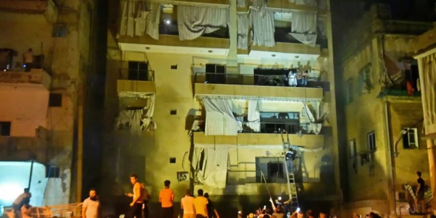 Feuerwehrleute helfen Menschen aus ihren Häusern