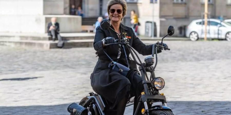 Gloria von Thurn und Taxis fährt mit einem Elektroroller zur Trauerfeier für Georg Ratzinger zum Dom St. Peter in Regensburg - ohne Helm. Foto: Armin Weigel/dpa