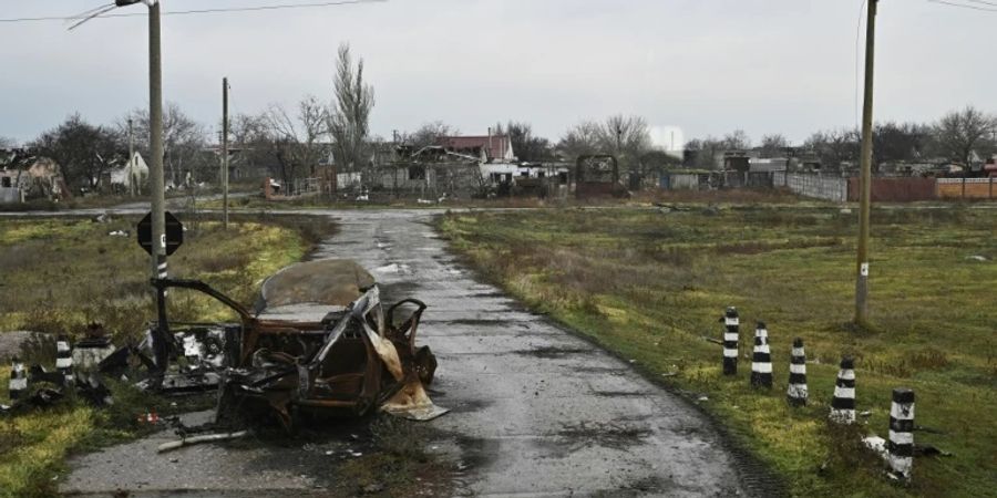 Ausgebranntes Auto und zerstörte Häuser in Mykolajiw