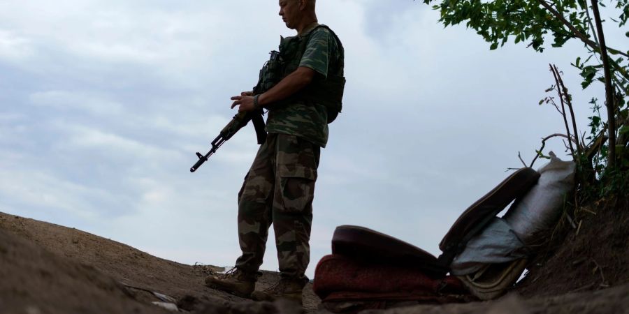 Ein ukrainischer Soldat hält in der Region Donezk Wache vor seinem Zelt.