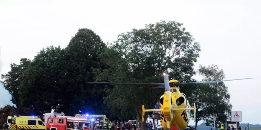 Das Feuer brennt noch, als einer von vier Rettungshubschraubern Verletzte ins Krankenhaus fliegt. Foto: Rocci Klein/dpa