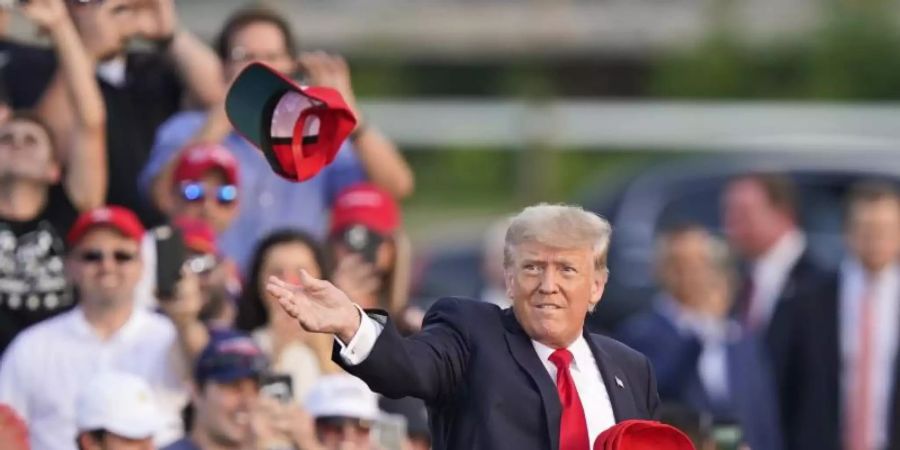 Donald Trump wirft «Save America»-Caps in die Menge. Foto: Tony Dejak/AP/dpa