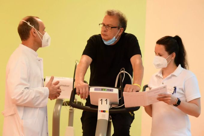 In der Fachklinik für Neurologie im Mediclin Reha-Zentrum sprechen der Chefarzt und Sporttherapeutin mit einem Long-Covid-Patienten. Long Covid