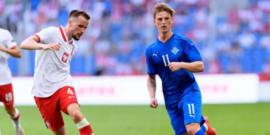 Polens (links Tomasz Kedziora) kam im Testspiel gegen Island mit Albert Gudmundsson nicht über ein Remis hinaus. Foto: Jakub Kaczmarczyk/PAP/dpa