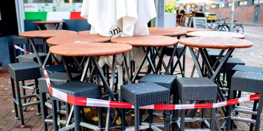 Tische und Stühle stehen abgesperrt vor einer Pizzeria in Hannover. Der von Bund und Ländern beschlossene Teil-Lockdown wird möglicherweise verlängert. Foto: Hauke-Christian Dittrich/dpa