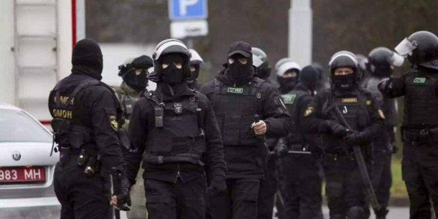 Bereitschaftspolizisten stehen am Rande eines Protests von Oppositionellen. Foto: -/AP/dpa