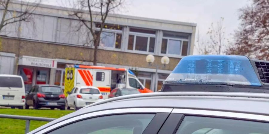 Einsatzfahrzeuge von Polizei und Rettungsdiensten stehen vor einer Schule in Östringen, an der ein 13-Jähriger einen Mitschüler attackierte. Foto: Julian Bucher/Einsatzreport 24/dpa