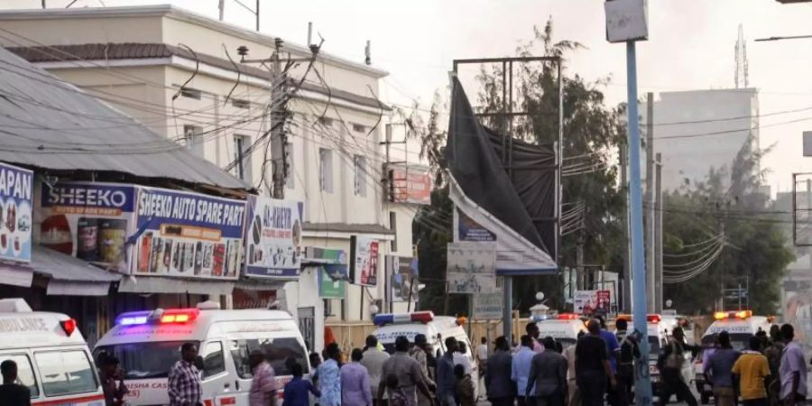 Krankenwagen, Sicherheitskräfte und Passanten versammeln sich auf der Strasse vor dem Afrik Hotel. Foto: Farah Abdi Warsameh/AP/dpa