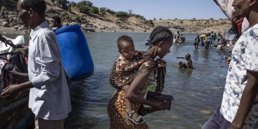 Flüchtlinge aus der Region Tigray kommen am Ufer des Tekeze-Setit im Sudan an. Foto: Nariman El-Mofty/AP/dpa