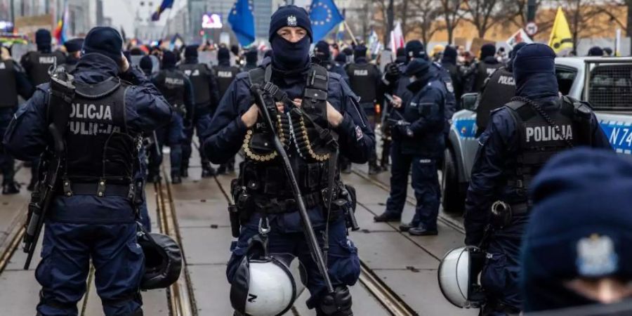 Polizisten in Schutzuniform stehen während einer Demonstration in der Hauptstadt Warschau Wache. Foto: Grzegorz Banaszak/ZUMA Wire/dpa