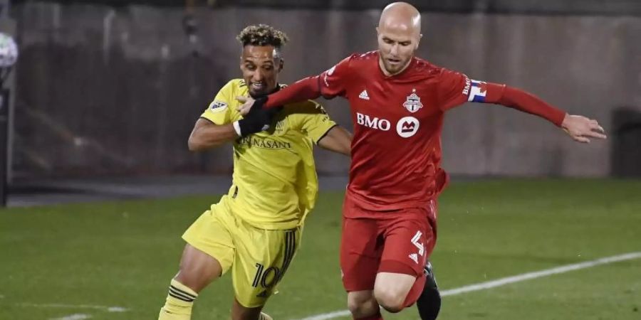 Hany Mukhtar (l) mischt mit Nashville die MLS auf. Hier im Duell mit Ex-Bundesligaprofi Michael Bradley vom Toronto FC. Foto: Jessica Hill/AP/dpa