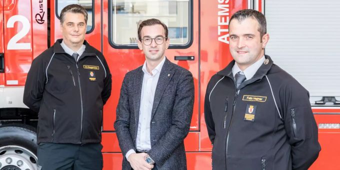 Der abtretende Kommandant Urs Baggenstos, Gemeinderat Drin Alaj und der neue Kommandant Felix Hegner vor dem Atemschutzfahrzeug Villette 2 im Feuerwehrdepot Cham (v.l.).