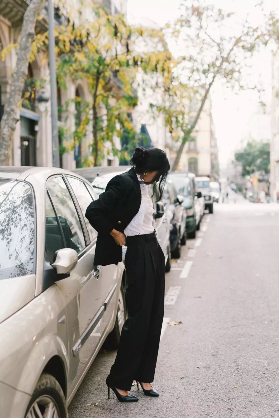 Asiatischer Frau im Business Look vor Auto.