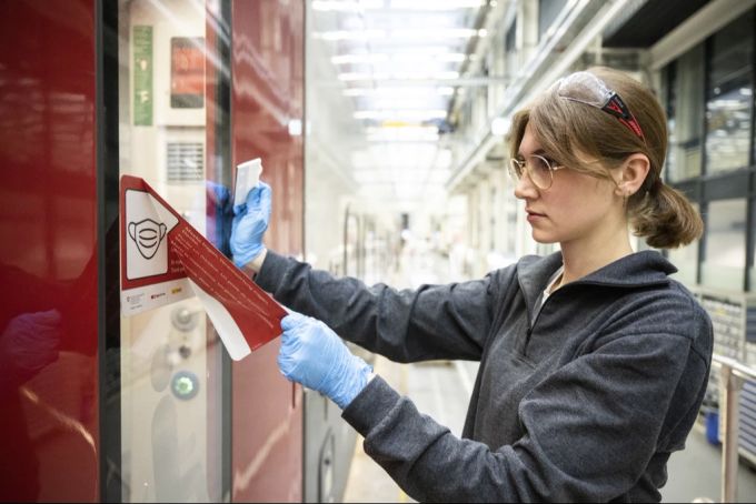 SBB-Mitarbeiterin Elena entfernt die Aufkleber zur Maskenpflicht in den Zügen, anlässlich der Aufhebung der Maskenpflicht im ÖV, in der Serviceanlage Herdern in Zürich am 1. April 2022. Maskenpflicht Aufhebung ÖV