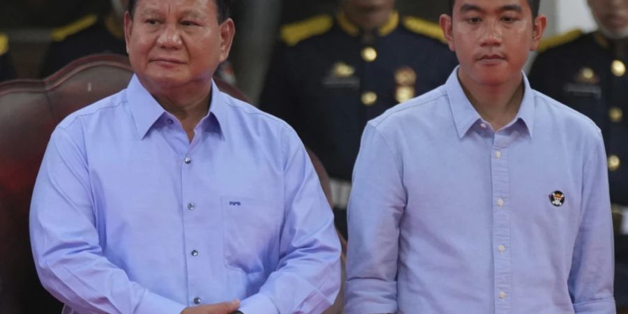 Präsidentschaftskandidat Prabowo Subianto (l) und sein Kandidat zum Vize-Präsidenten Gibran Rakabuming Raka stehen auf der Bühne während der Unterzeichnungszeremonie der «Erklärung für einen friedlichen Wahlkampf» im Gebäude der Allgemeinen Wahlkommission. Foto: Tatan Syuflana/AP/dpa