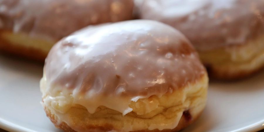 Berliner bzw. Pfannkuchen auf einem Teller. Zu den Lebensmitteln, die nennenswerte Mengen an trans-Fettsäuren enthalten können, gehören nach DGE-Angaben Back- und Süsswaren.