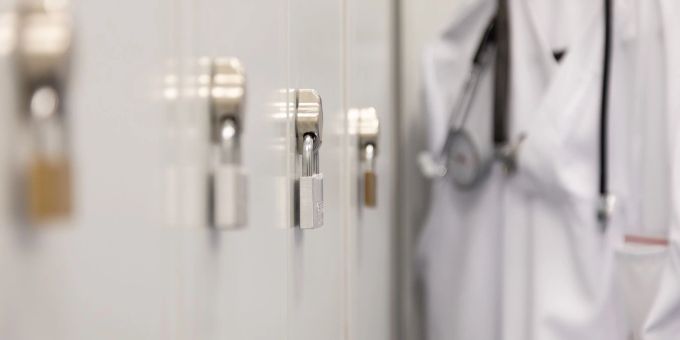 Die Spinds der Mitarbeiter in einem Krankenhaus sind mit Vorhängeschlössern verschlossen. maskenpflicht