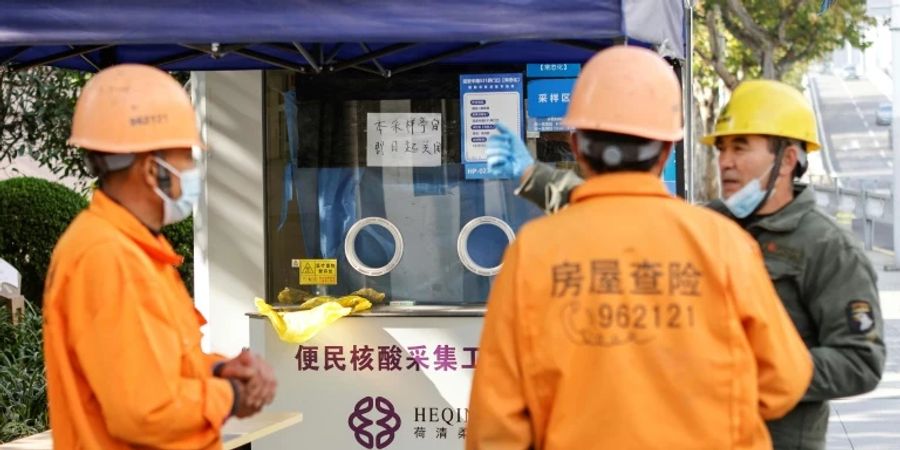 Arbeiter vor geschlossener Teststation in Shanghai