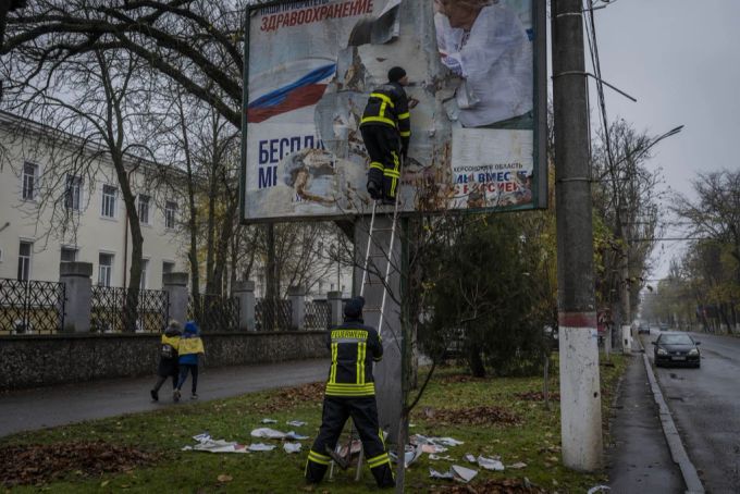 Nach der Rückeroberung im Ukraine-Krieg werden russische Propaganda-Plakate in Cherson abgenommen. Ukraine Krieg