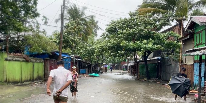 Auf diesem Videostandbild gehen Einheimische auf einer durch starken Regen überfluteten Strasse, während sich der Zyklon Mocha Myanmar nähert. Uncredited/AP/dpa Zyklon Mocha