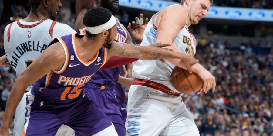 Denvers Nikola Jokic (r) verteidigt den Ball gegen Cameron Payne von den Phoenix Suns.