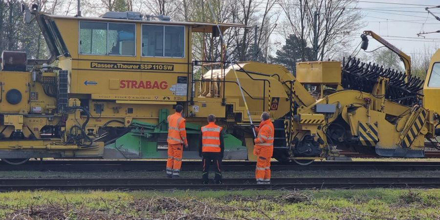 Bahn-Mitarbeiter untersuchen nach dem Unfall die Leitung in Langenhagen.