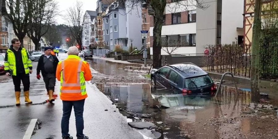 Ein Auto ist nach einem Wasserrohrbruch in der Mainzer Strasse in Koblenz im Schlamm versunken. Foto: Handout/evm
