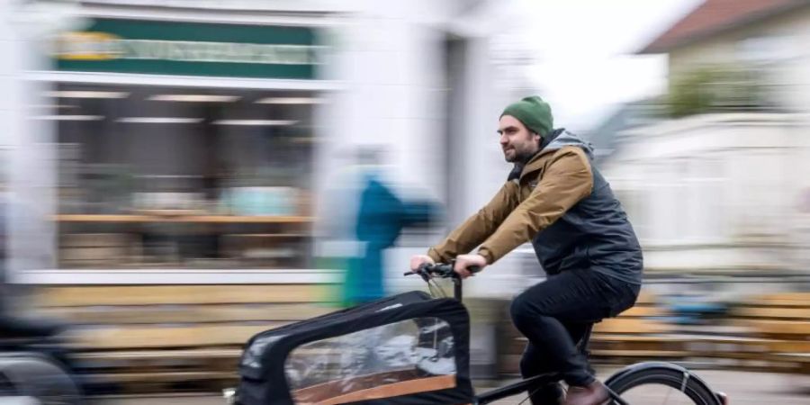 Ernst Schäfer, Mitbegründer des Lastenradverleihs «Rädchen für alles», fährt auf einem Lastenrad durch die Innenstadt. Foto: Sina Schuldt/dpa