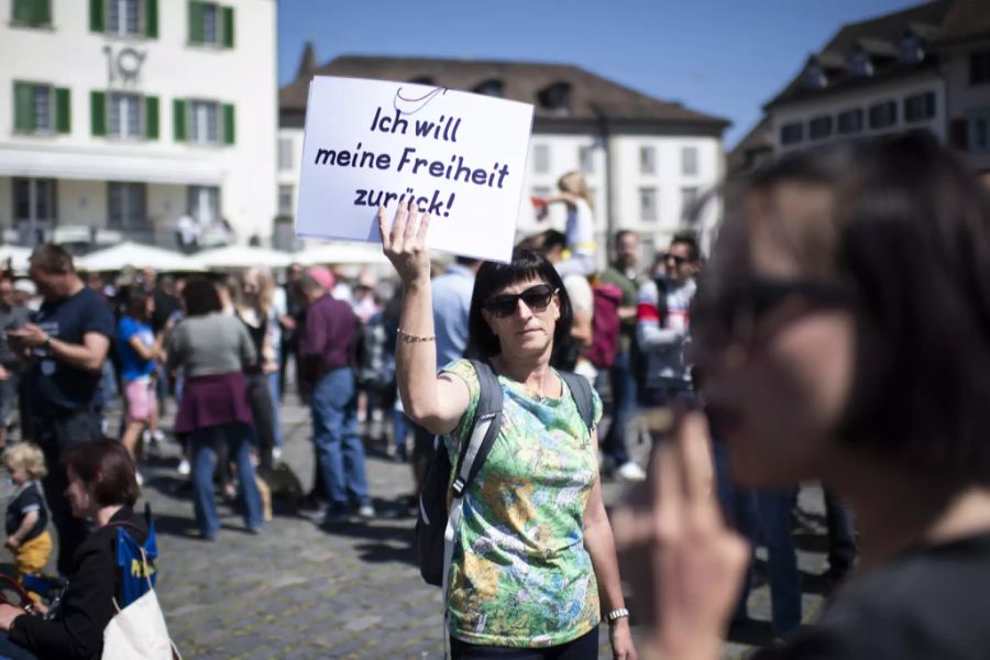 Eine Frau demonstriert mit einem Plakat gegen die Corona-Massnahmen.