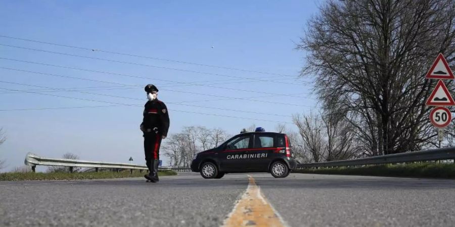 Ein Carabinieri kontrolliert den Grenzbereich des abgesperrten Gebietes um die unter Quarantäne stehenden Stadt Codogno. Foto: Antonio Calanni/AP/dpa