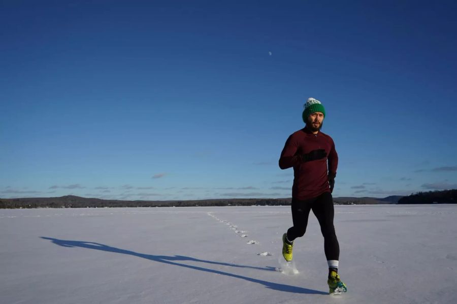 Mann joggt im Schnee