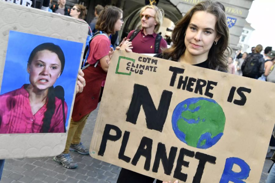 Eine Demonstrantin am Klimastreik zeigt ein Schild mit Aufschrift.