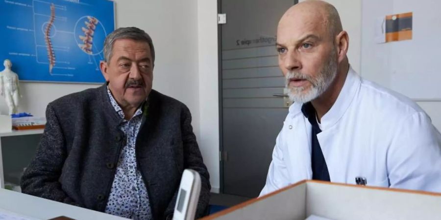 Dr. Gerhard Paulsen (Simon Licht, r) wird von Hofer (Joseph Hannesschläger, l) zum Streit mit seinem ehemaligen Kollegen befragt, der ermordet wurde. Foto: Bojan Ritan/ZDF/dpa