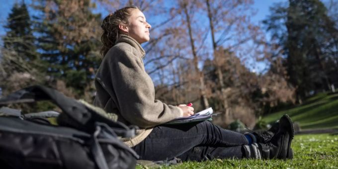 Eine Frau sitzt in der Sonne. Letztes Wochenende war es verhältnismässig sehr warm. Sonne Sommer warm