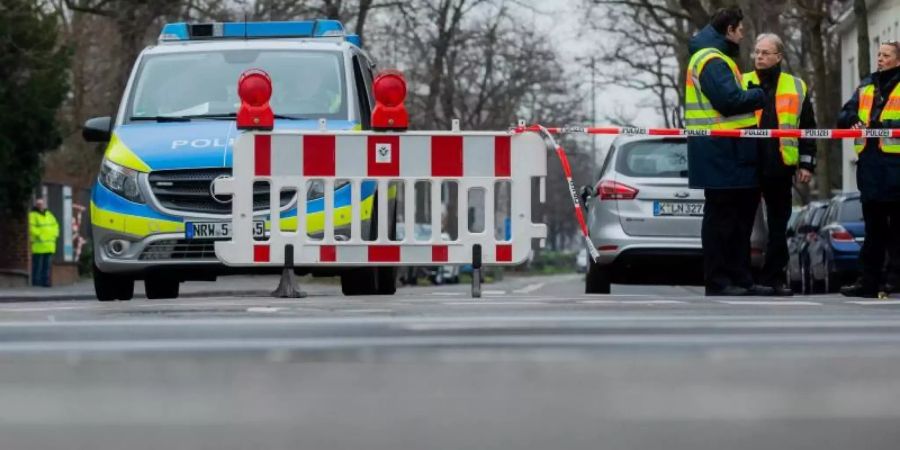 Polizisten sperren eine Strasse vor dem Gelände der Kölner Universitätsklinik. In der Nähe war eine 500 Kilogramm schwere Fliegerbombe aus dem Zweiten Weltkrieg entdeckt worden. Foto: Rolf Vennenbernd/dpa