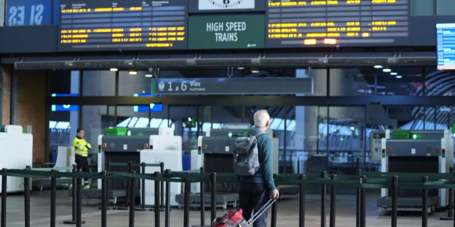 Ein Mann mit Gep‰ck steht alleine am Bahnhof Santa Justa vor dem Durchgang zu den Gleisen und blickt auf eine Anzeigetafel. Bei dem Zusammenstofl zweier Z¸ge in Urda kamen ...