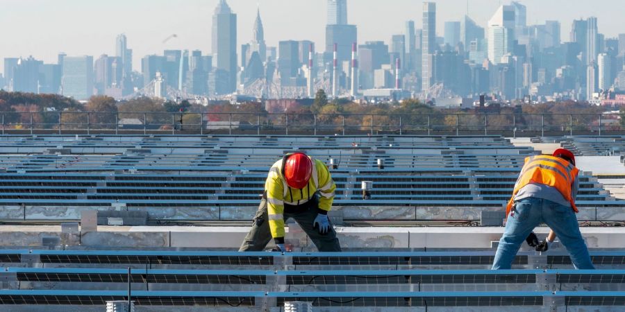 Elektriker installieren im New Yorker Stadtteil Queens Solarpaneele. Die US-Regierung hebt Zoll-Ausnahmen für bestimmte Solar-Importe auf.