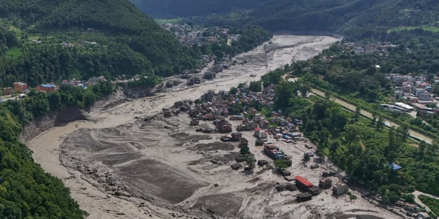 Nach Sturzfluten im nepalesischen Distrikt Nuwakot stehen beschädigte Häuser gefährlich nahe an den angeschwollenen, mit Treibgut verstopften Ufern des Trishuli-Flusses. Eine massive...