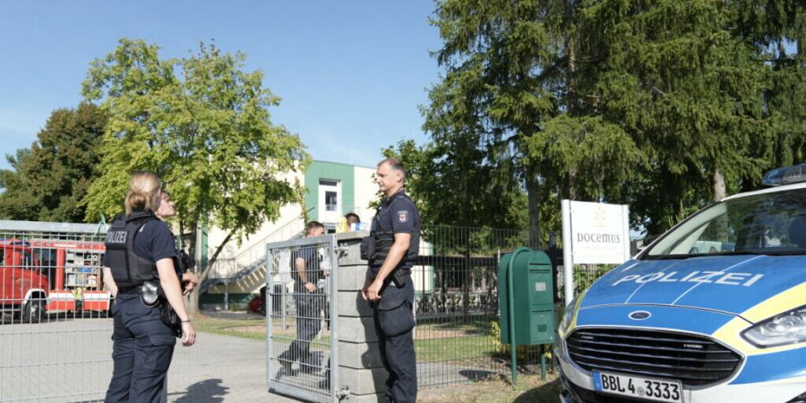 Polizisten stehen vor der Schule in Gosen-Neu Zittau. Foto: Manuel Genolet/dpa