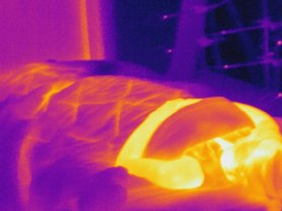 Das Bild zeigt eine Person, die in einem Bett liegt, das nicht gekühlt ist. Die Temperaturen zeigen kühle Bereiche (blau) bis warme Bereiche (gelb, rot).