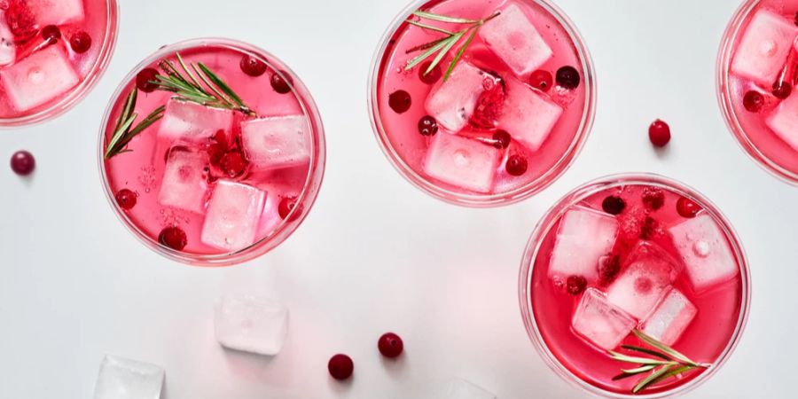 Weingläser von oben Eiswürfel Beeren alkoholhaltiges rosanes Getränk