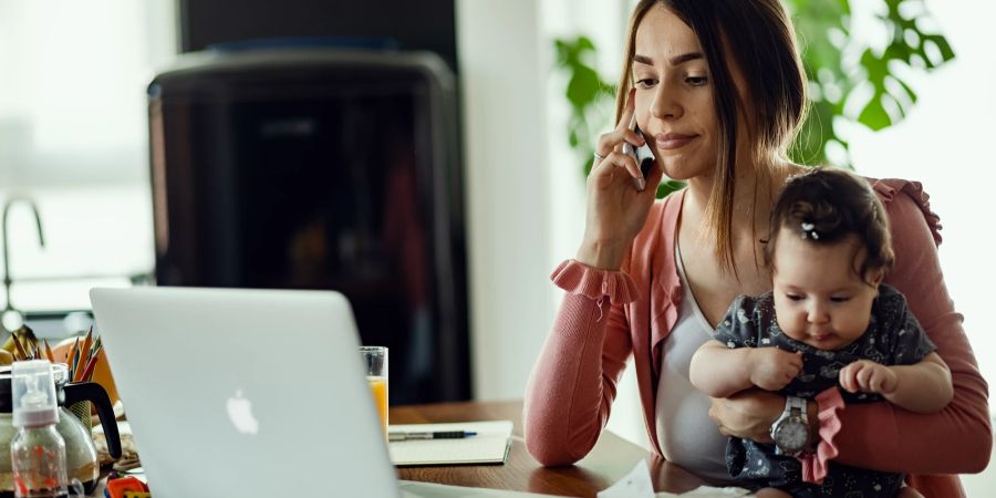 Mutter mit Baby am Telefon