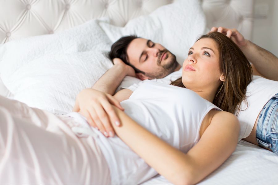 Paar nachdenklich auf einem Bett
