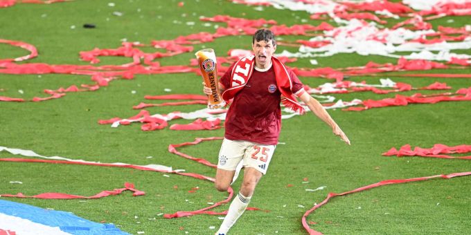 Thomas Müller rennt bei der Meisterfeier mit Bier über das Feld. Thomas müller
