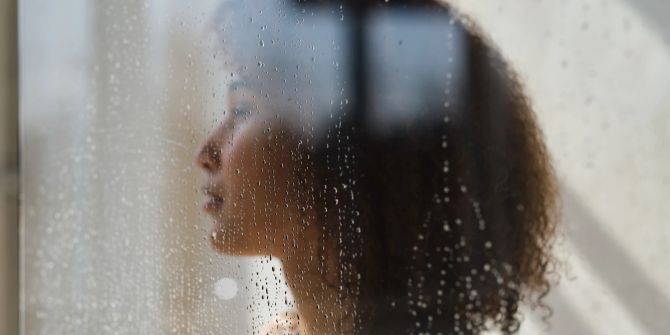 Nachdenkliche Frau, Regen am Fenster